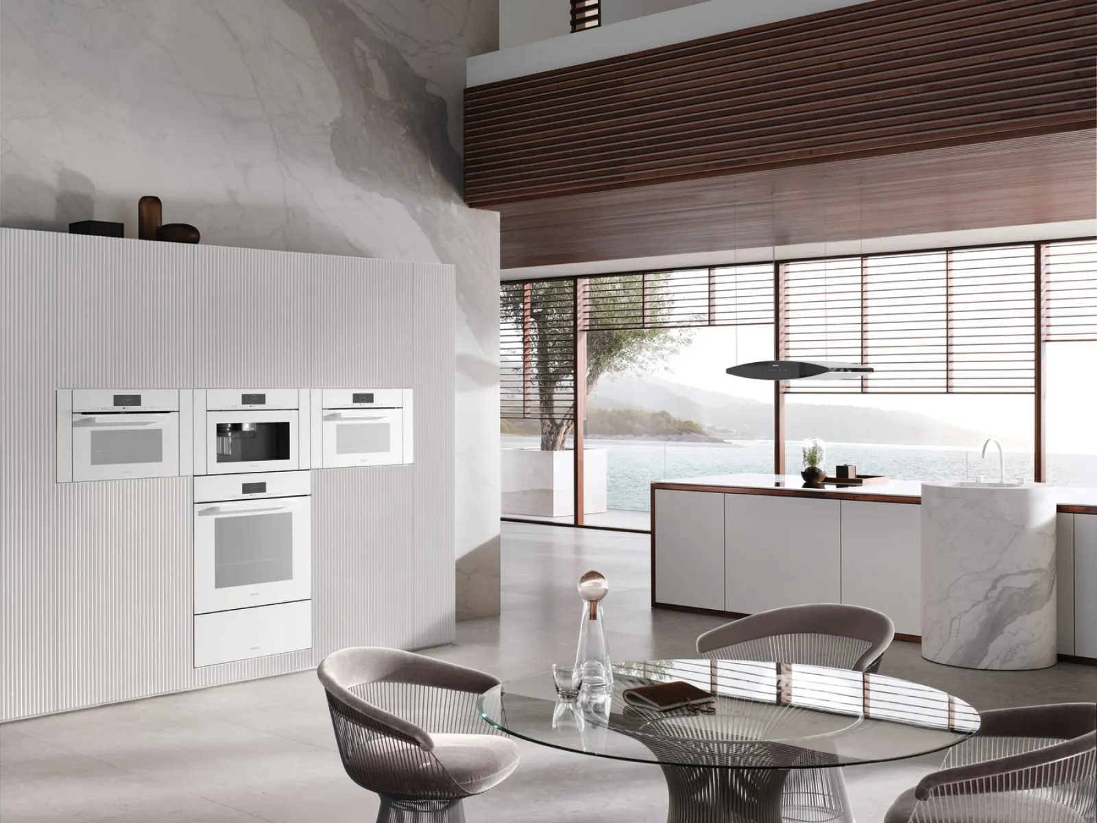 Modern kitchen with sleek cabinetry, elegant dining table, and large windows showcasing a scenic view.