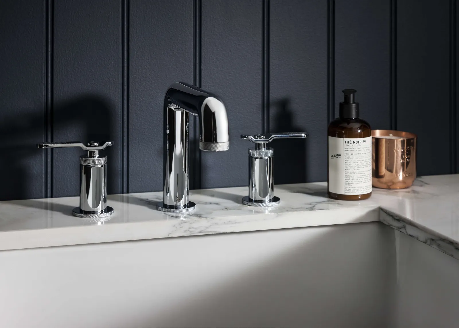 a sink with a bottle of soap and a couple of faucets