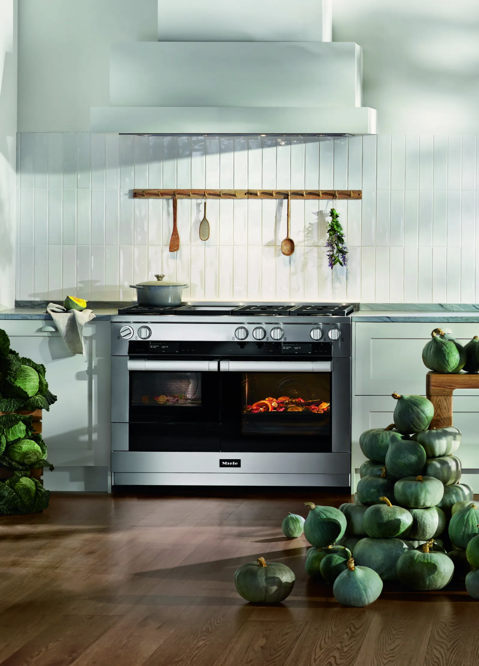Modern kitchen with a Miele oven and fresh vegetables surrounding it, highlighting culinary elegance.