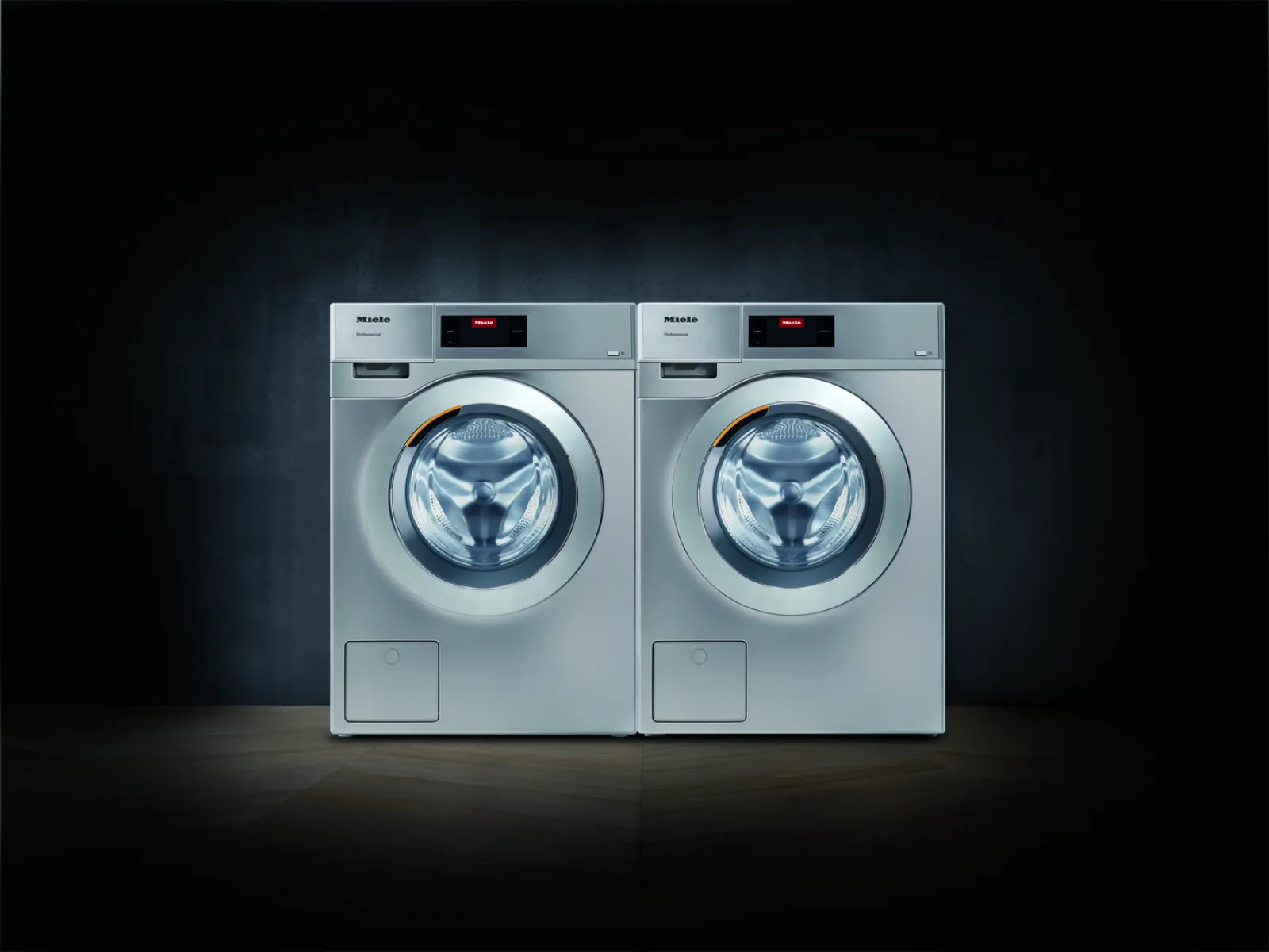 Two modern Miele washing machines displayed against a dark background for a sleek look.