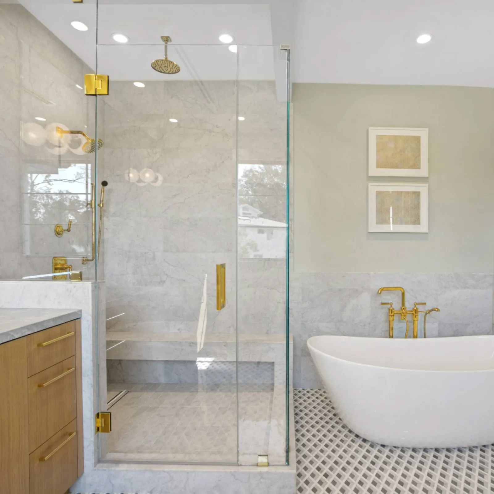 Elegant modern bathroom featuring a glass shower, freestanding tub, and gold fixtures against marble tiles.