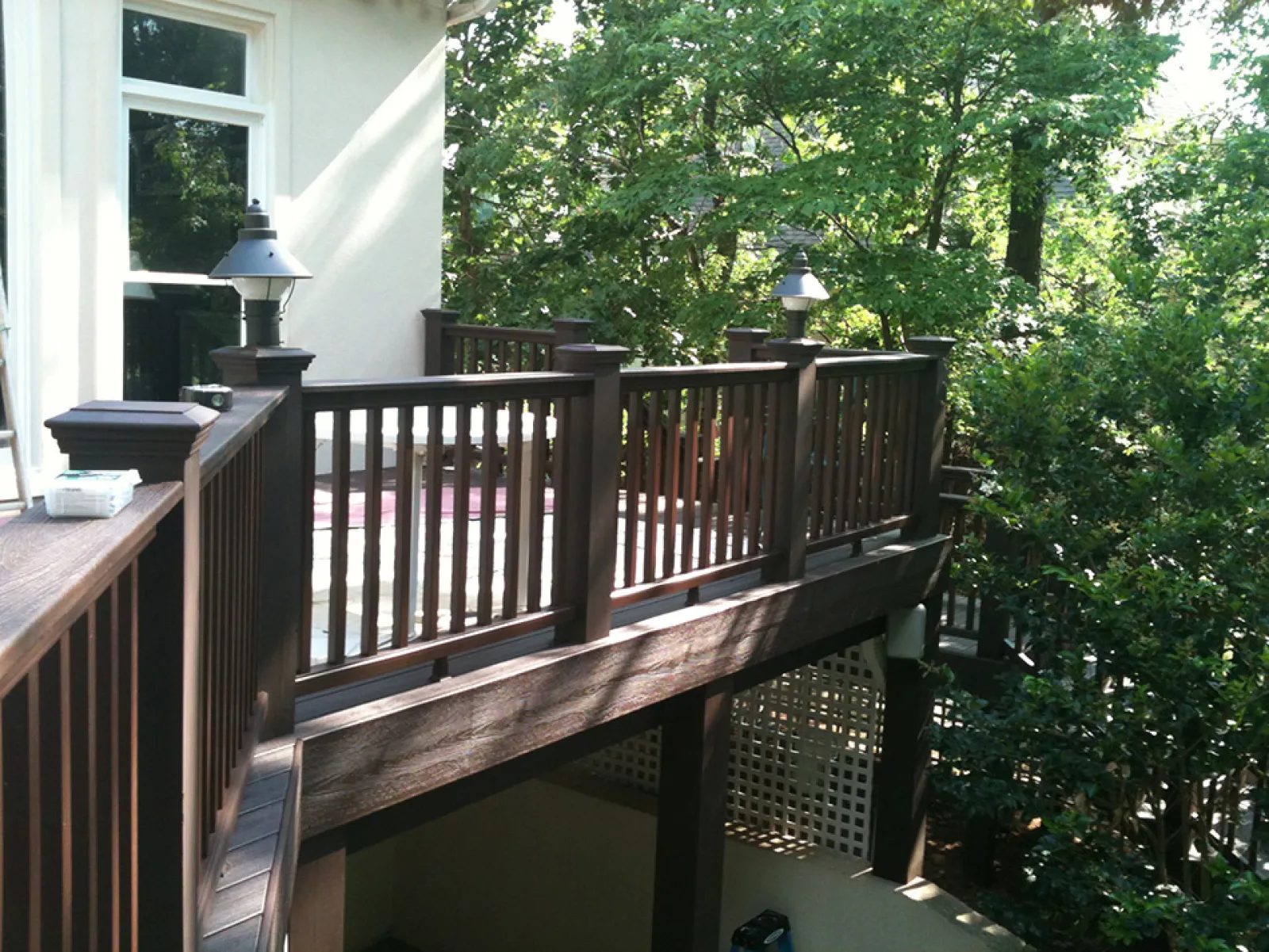 a deck with a railing and trees