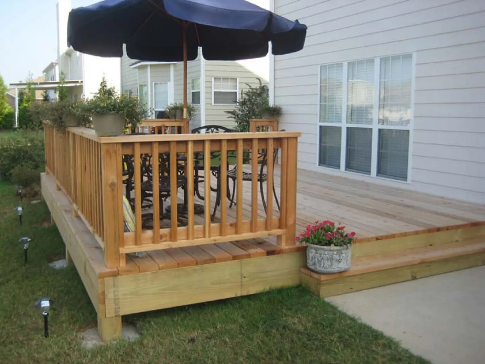 a deck with a umbrella and plants