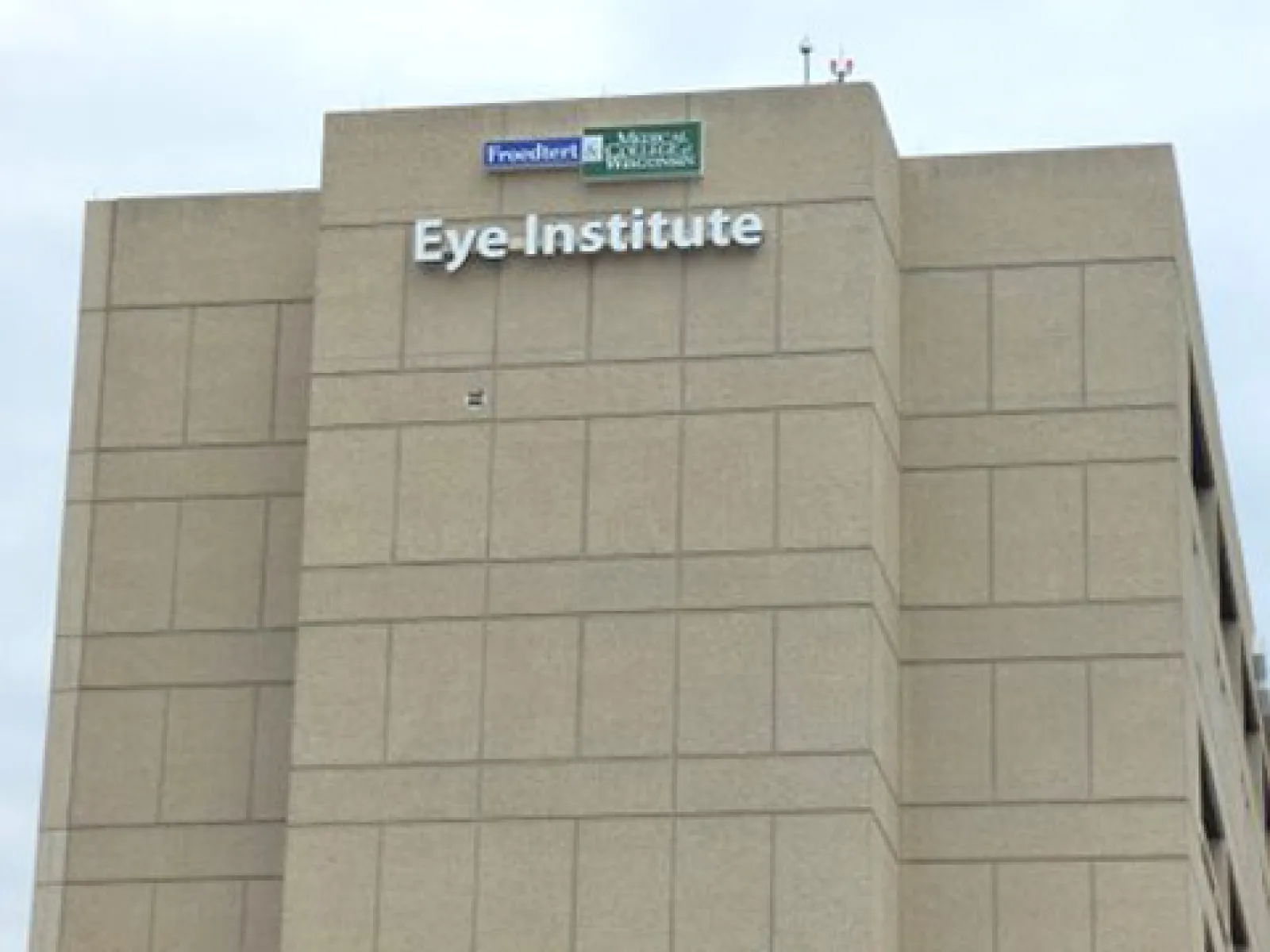 Exterior view of a beige Eye Institute building with Freeport and Mercy Medical Center signage on top.