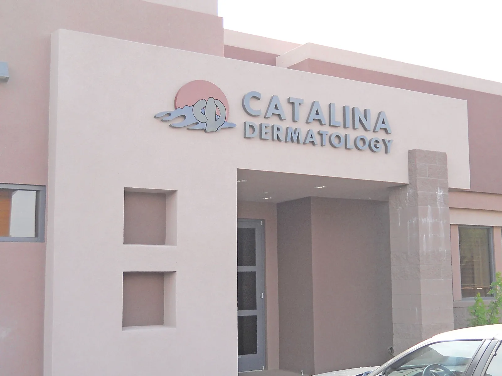 Exterior view of Catalina Dermatology office with beige walls and signage above entrance.