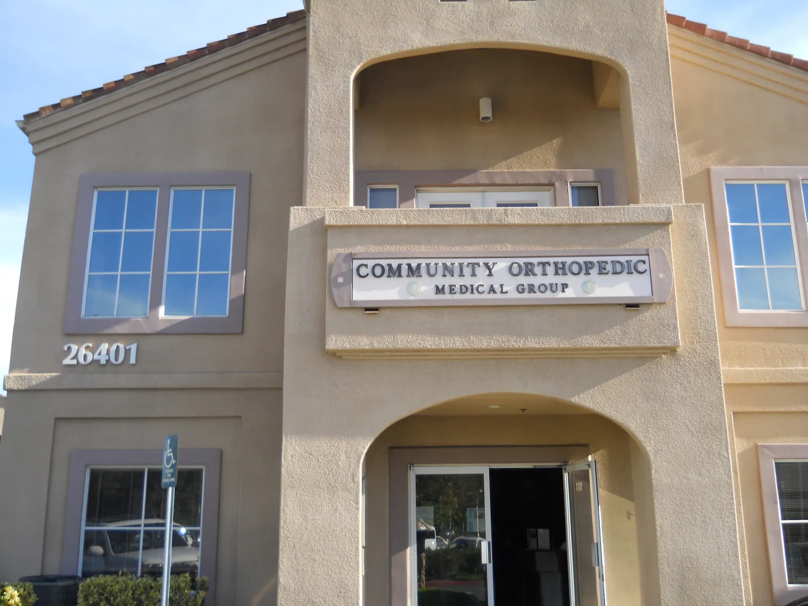 Exterior view of Community Orthopedic Medical Group building with address 26401 and entrance door.