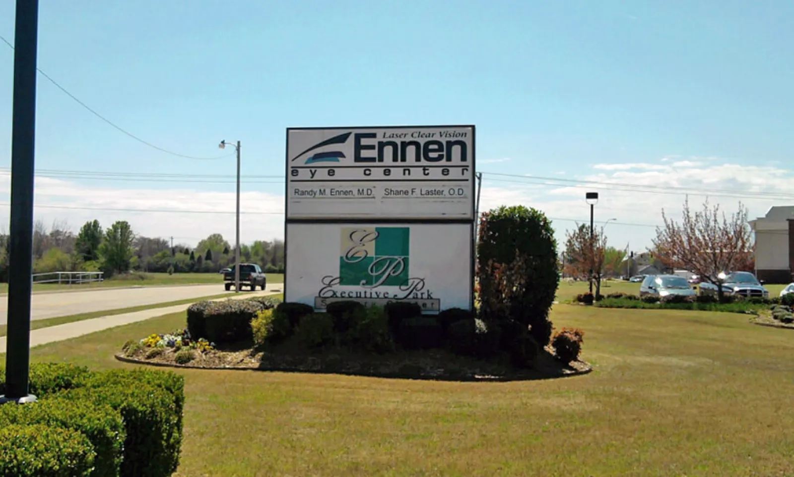 Ennen Eye Center sign at Executive Park on a sunny day with cars and greenery in the background