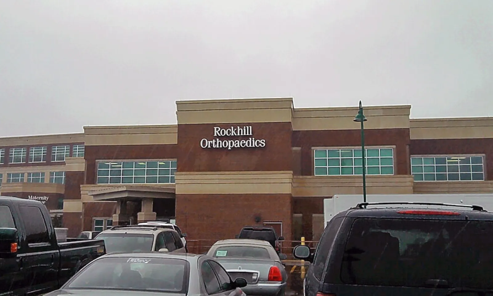 Rockhill Orthopaedics medical office building with parked cars in front on a cloudy day.