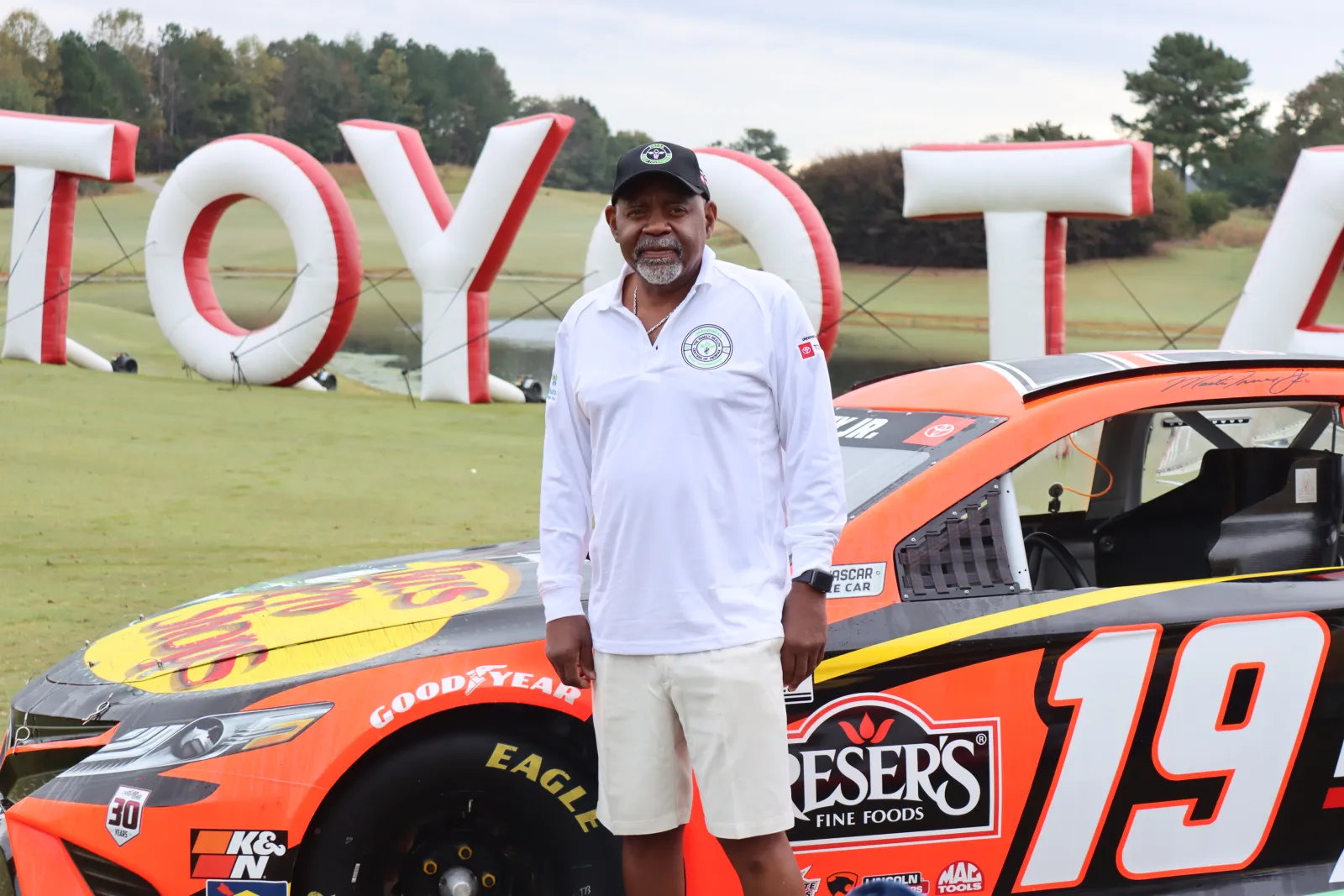 a man standing next to a race car