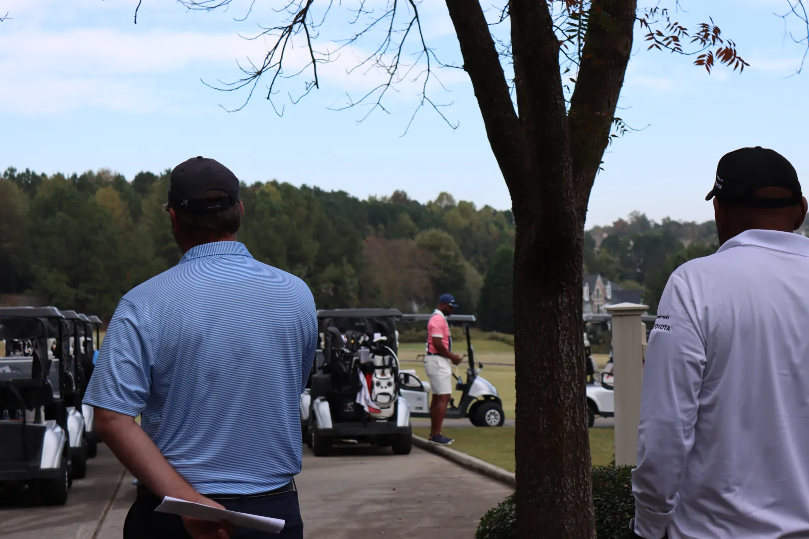 a couple of men looking at a golf cart