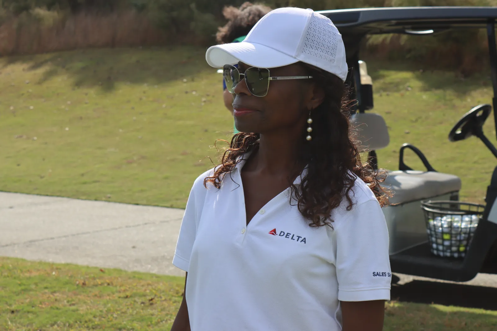a woman wearing a white shirt and sunglasses