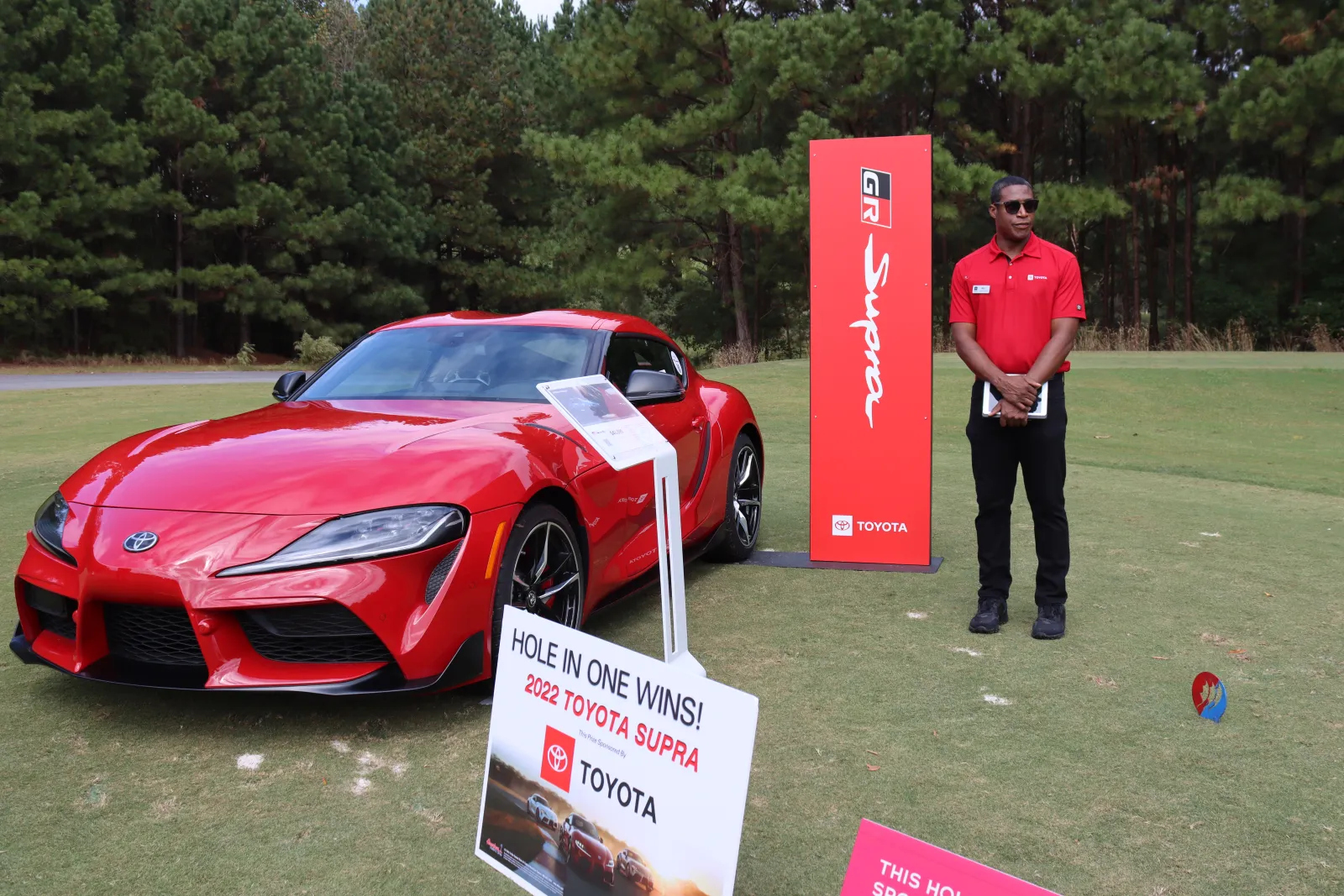 a person standing next to a red sports car