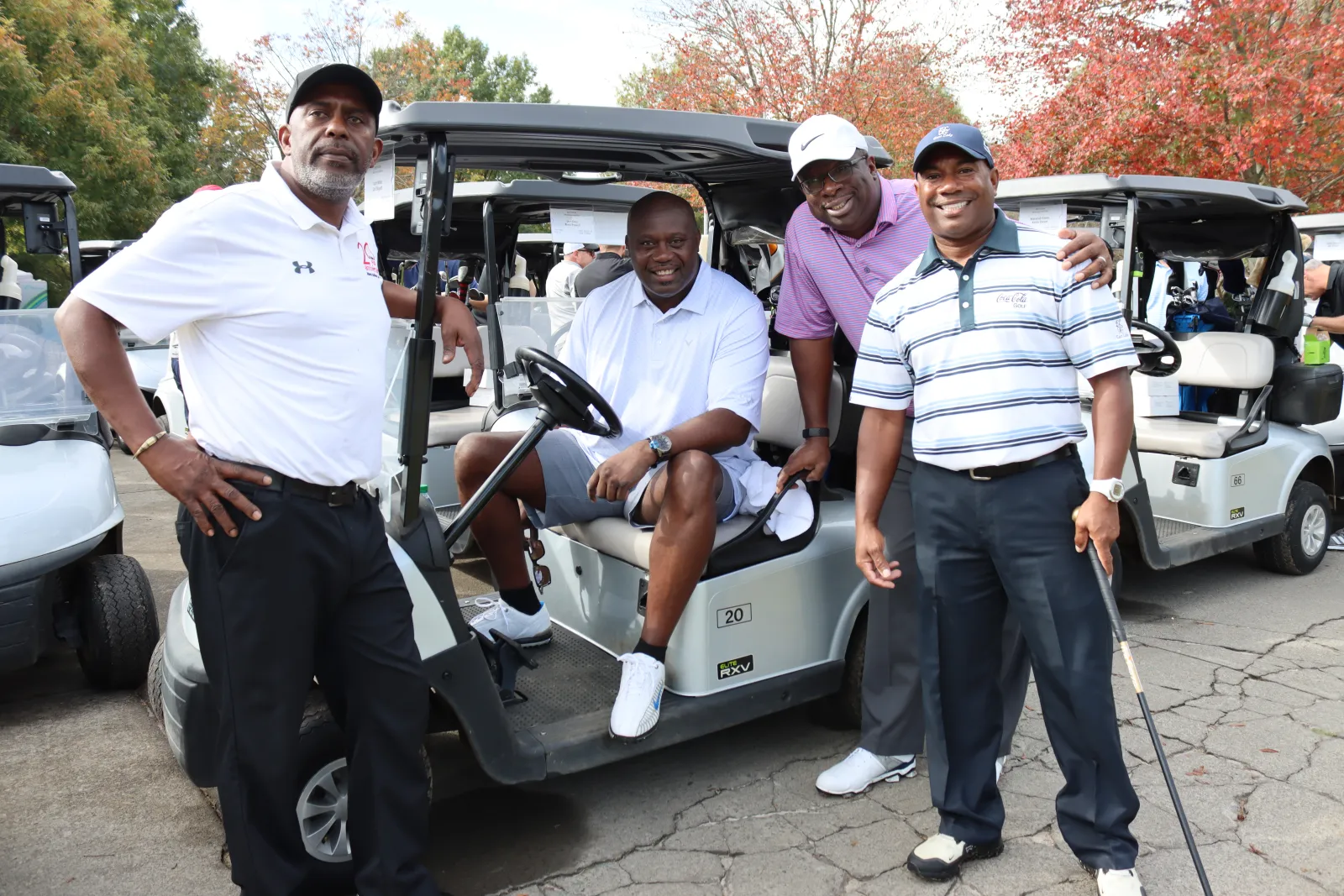 a group of people standing around a golf cart