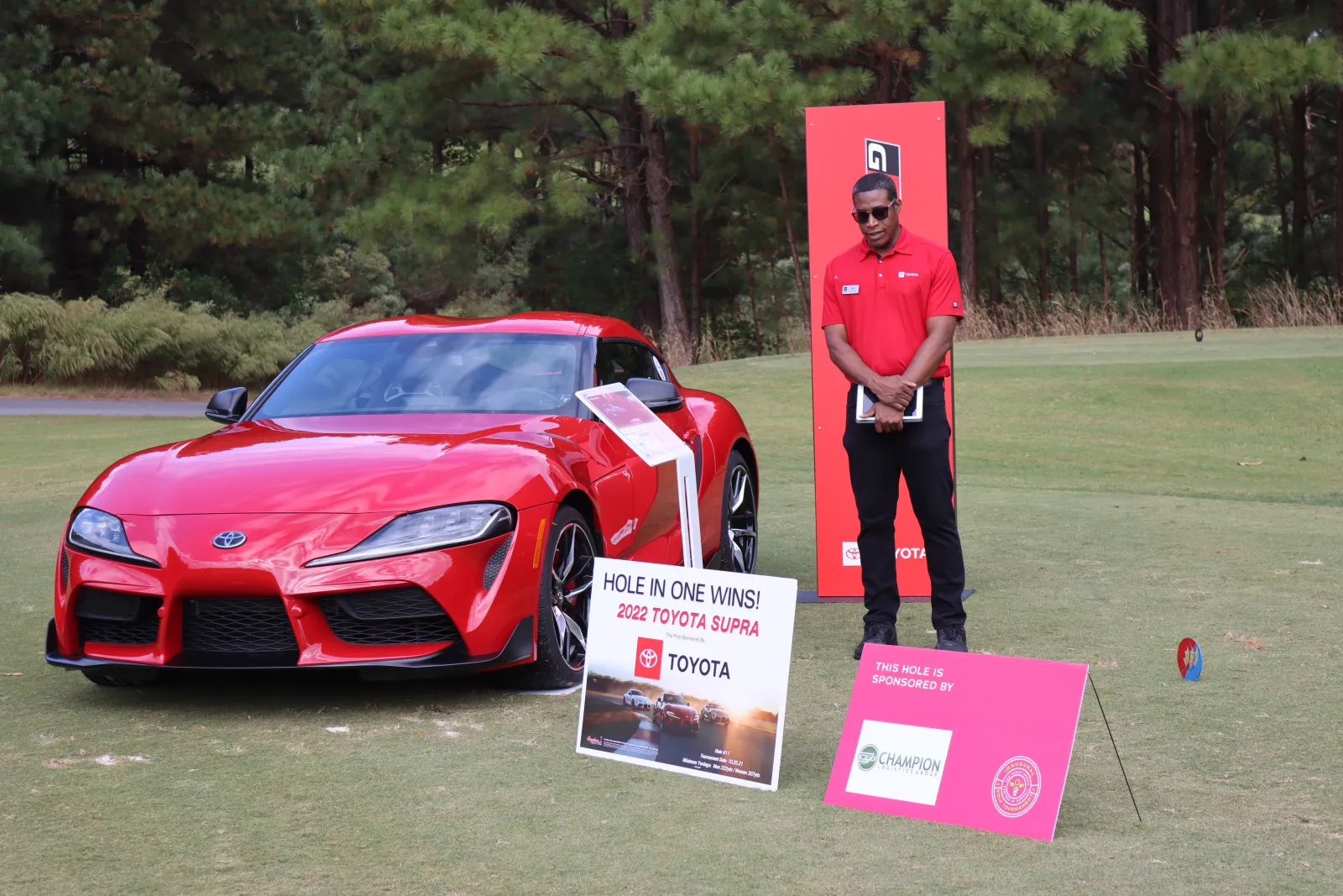 a person standing next to a red sports car