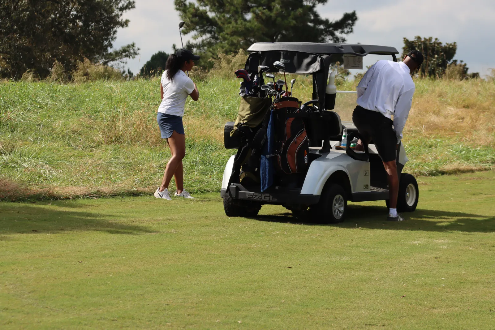 a man and woman pushing a golf cart