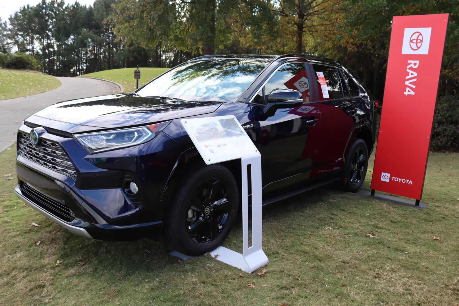 a car parked on grass near a sign