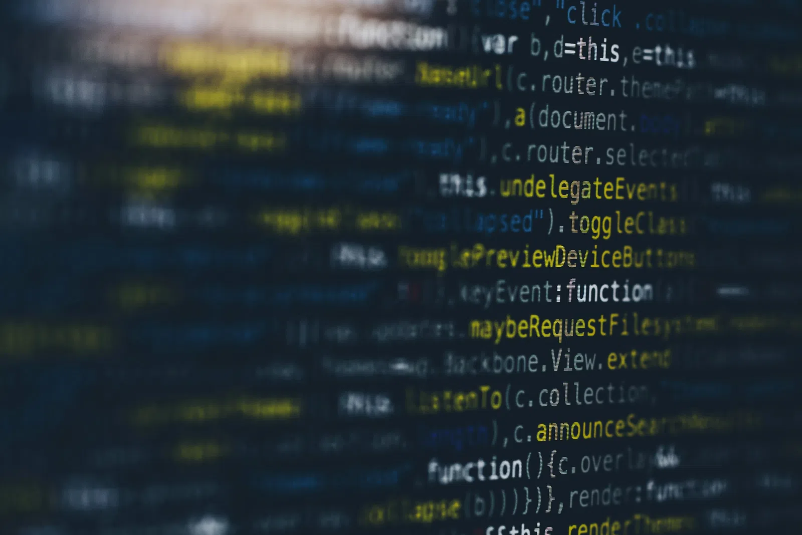 Blurry close-up of computer code with highlighted JavaScript keywords and functions on a dark screen.