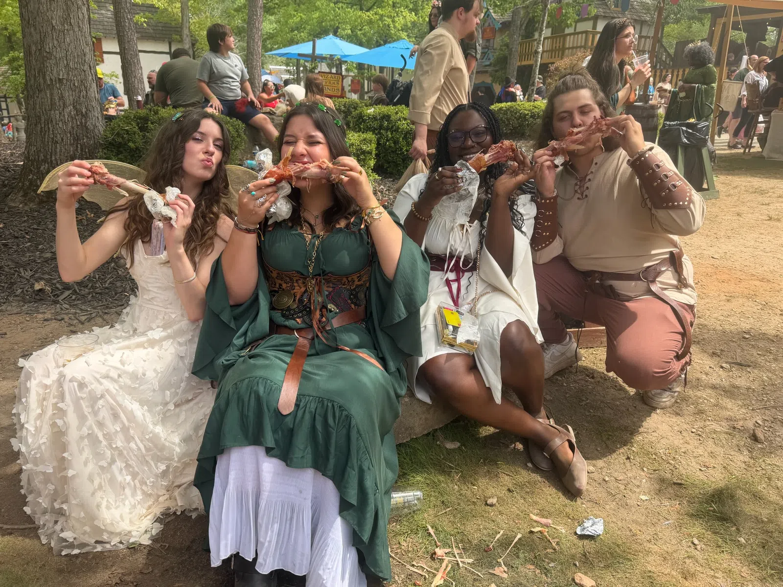 Four friends share turkey legs at the Georgia Renaissance Festival