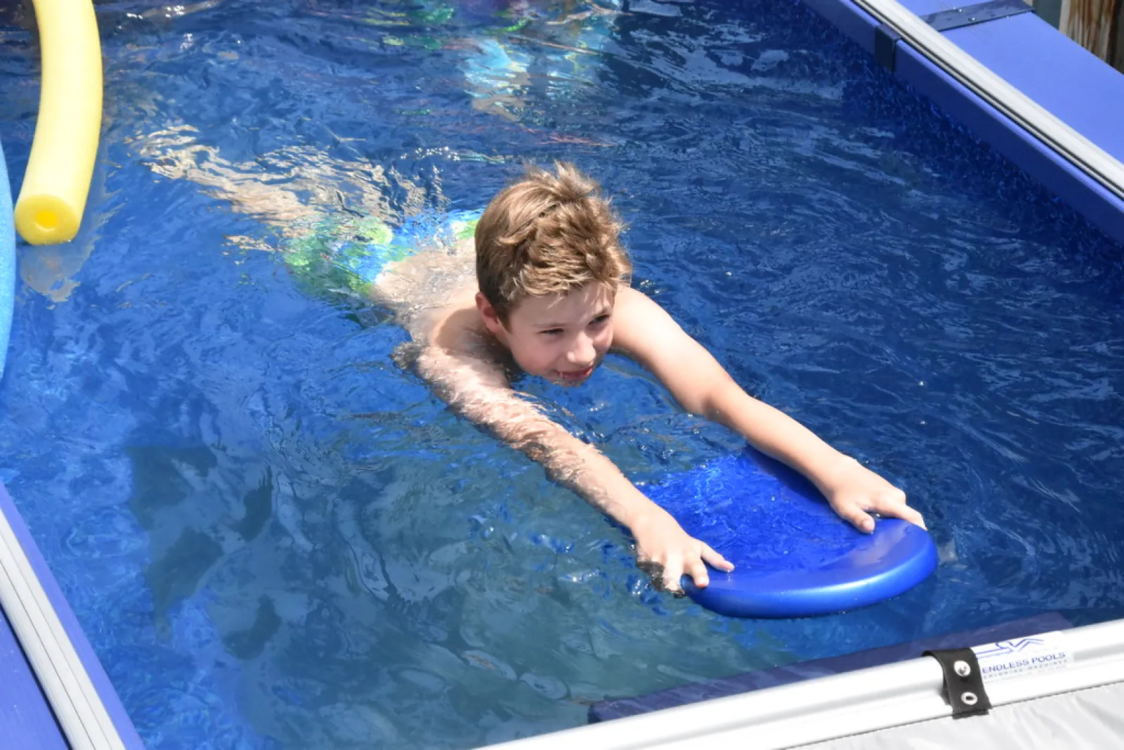 a boy on a surfboard in a pool