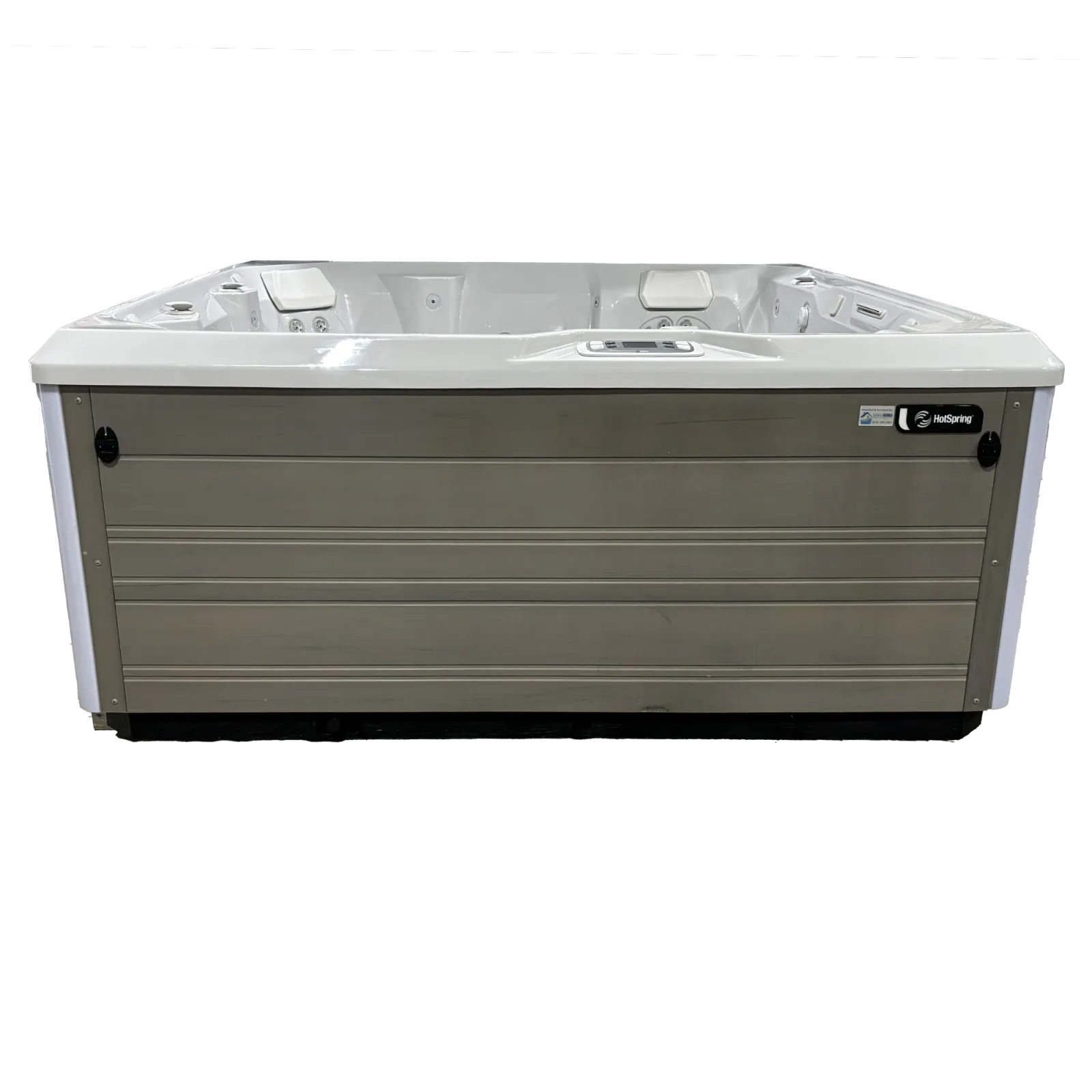White and gray HotSpring brand outdoor hot tub with built-in headrests and control panel.