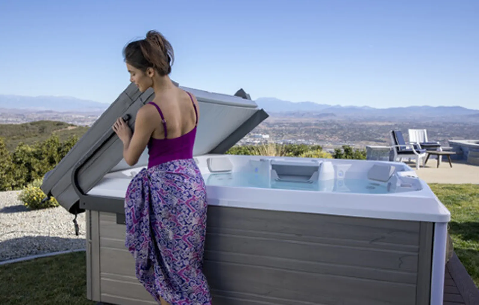 a woman standing next to a hot tub