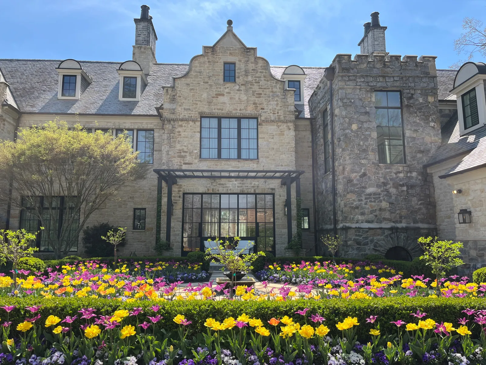 a large stone building with many windows and flowers in front of it