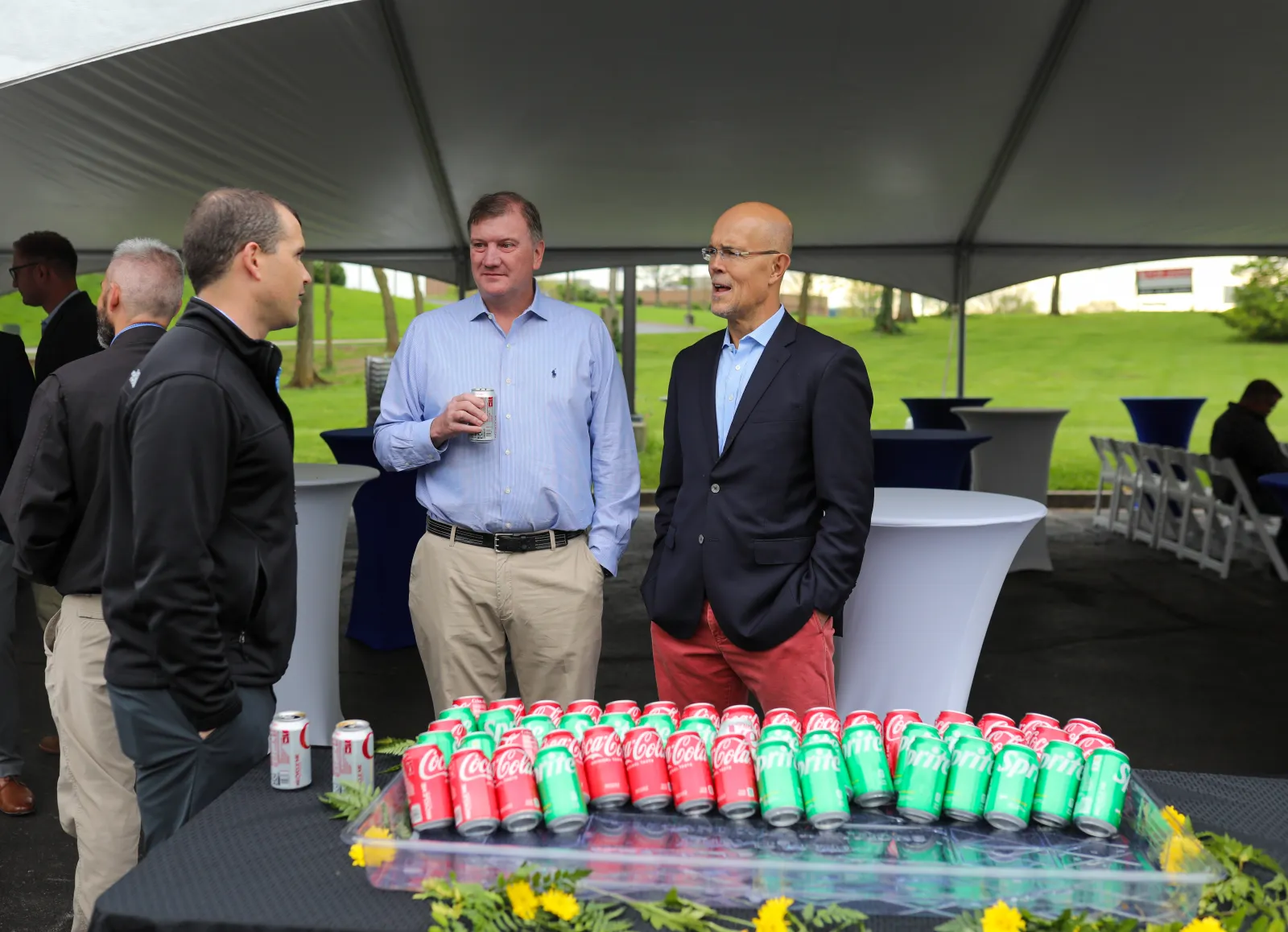 a group of men standing around a table with cups on it