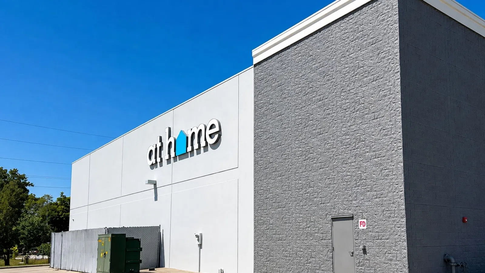 Exterior of an At Home retail store with clear blue sky and gray and white building walls