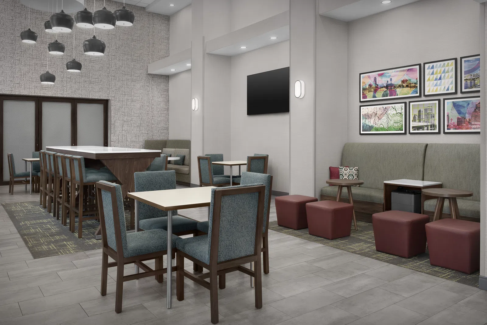 Modern hotel lobby with seating areas, pendant lights, artwork on walls, and neutral tones in furniture and flooring