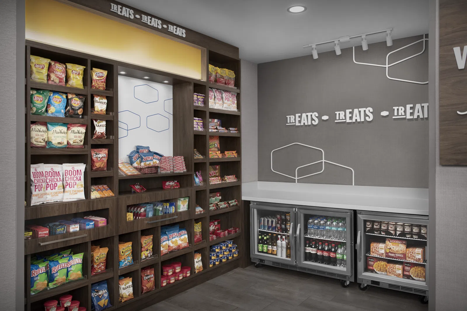 Snack and beverage display with assorted chips, sodas, bottled water, and frozen meals in a modern retail corner.