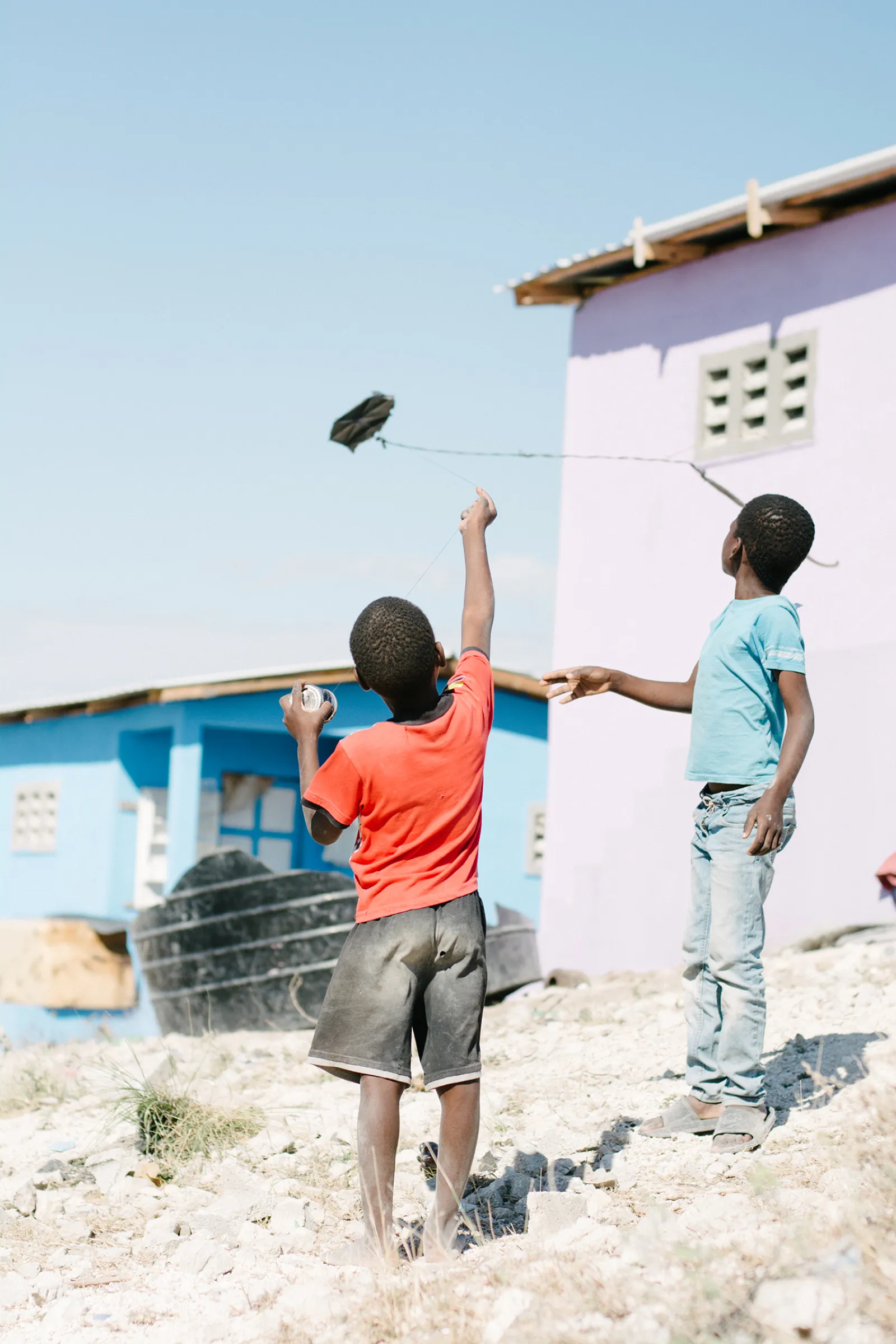 a couple of kids playing with a bird in the air