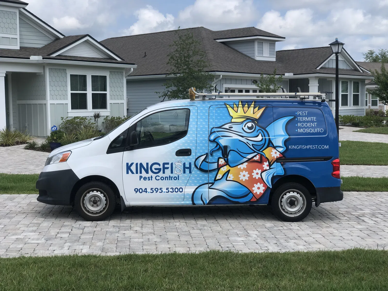 Kingfish Pest Control van with Kingfish logo and contact information parked in suburban driveway.