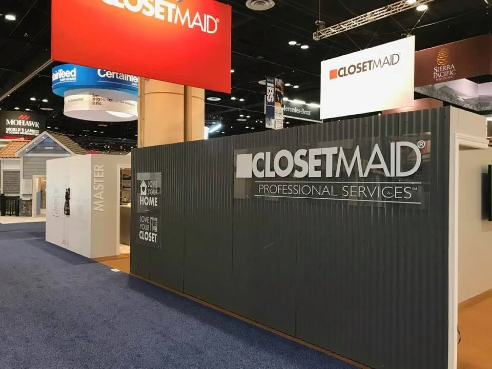 ClosetMaid professional services booth at a trade show with branded signage and product displays.