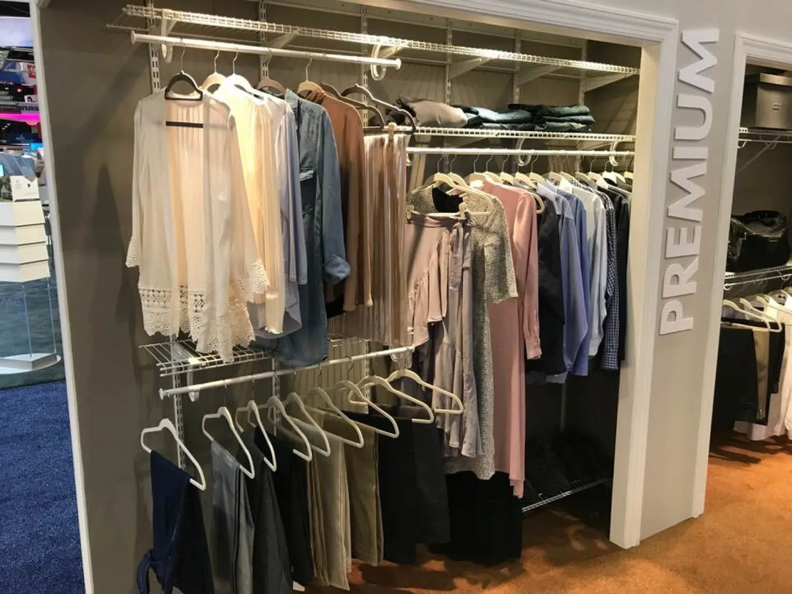 Closet organizer displaying neatly hung clothes in neutral tones labeled as premium wear