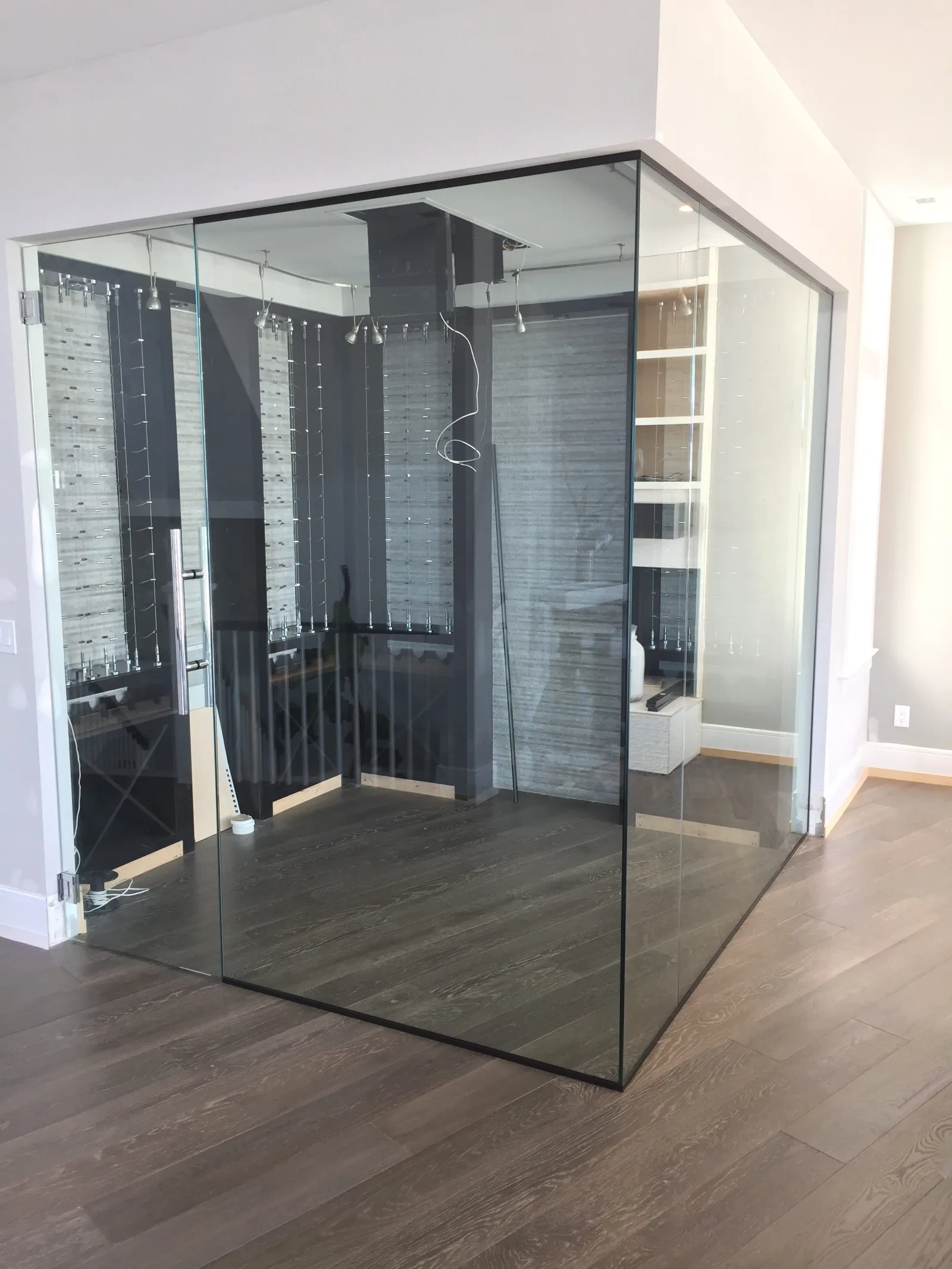 Modern empty glass-enclosed office corner with wooden flooring and white walls in a bright space