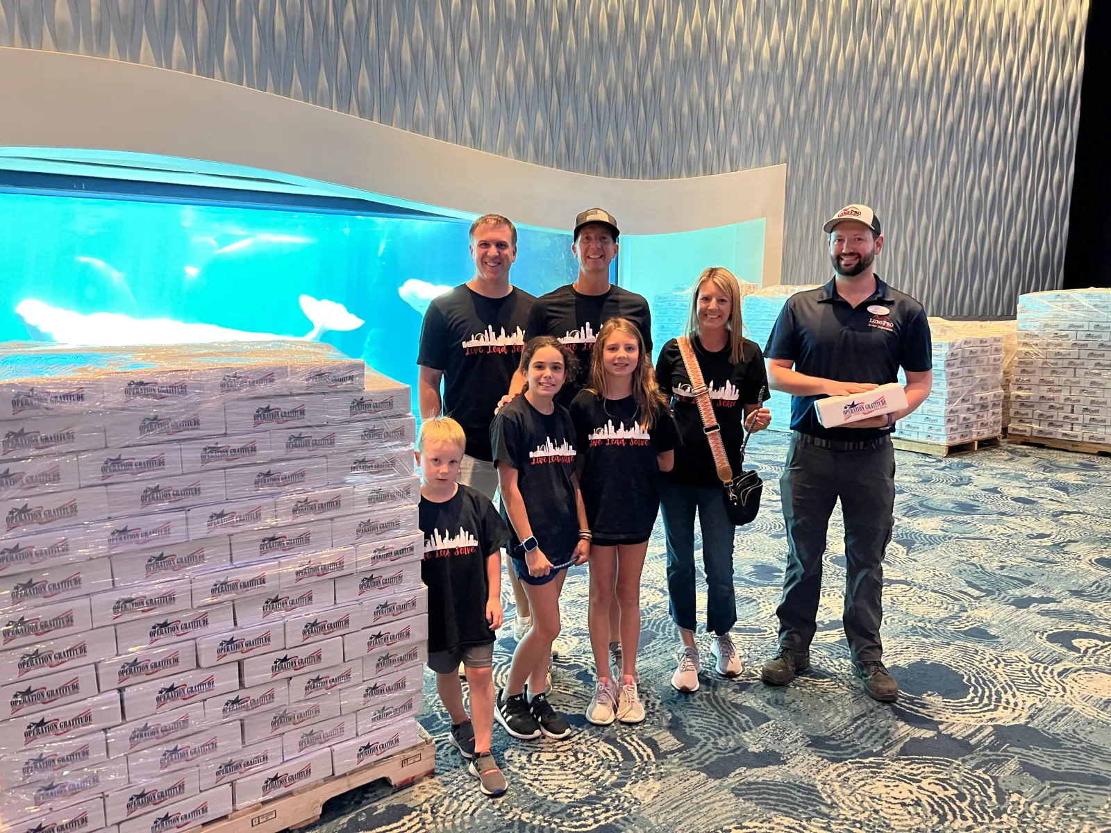 a group of people posing for a photo in front of a large poster