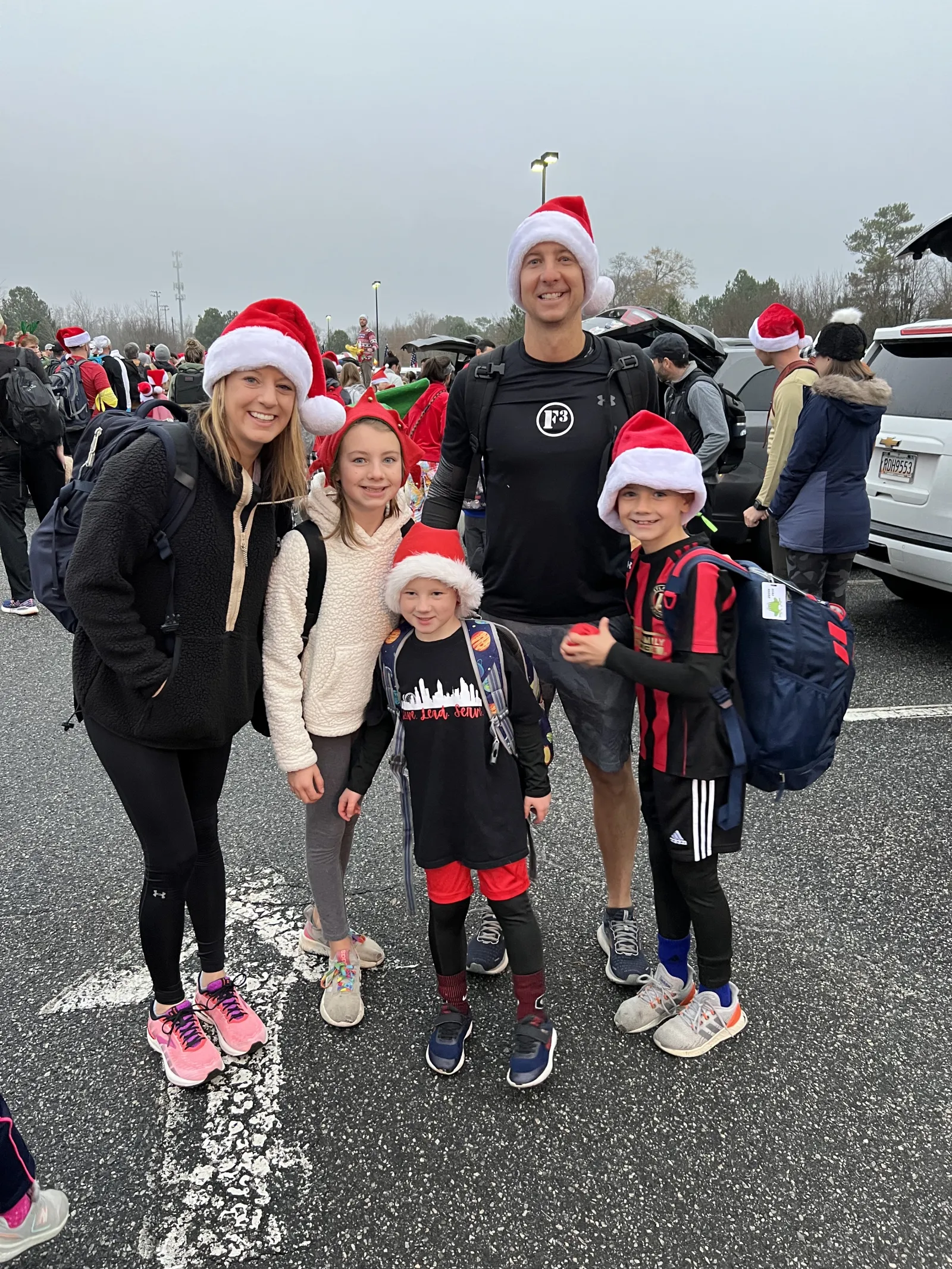 Caitlin Carmichael et al. wearing santa hats and walking on a street