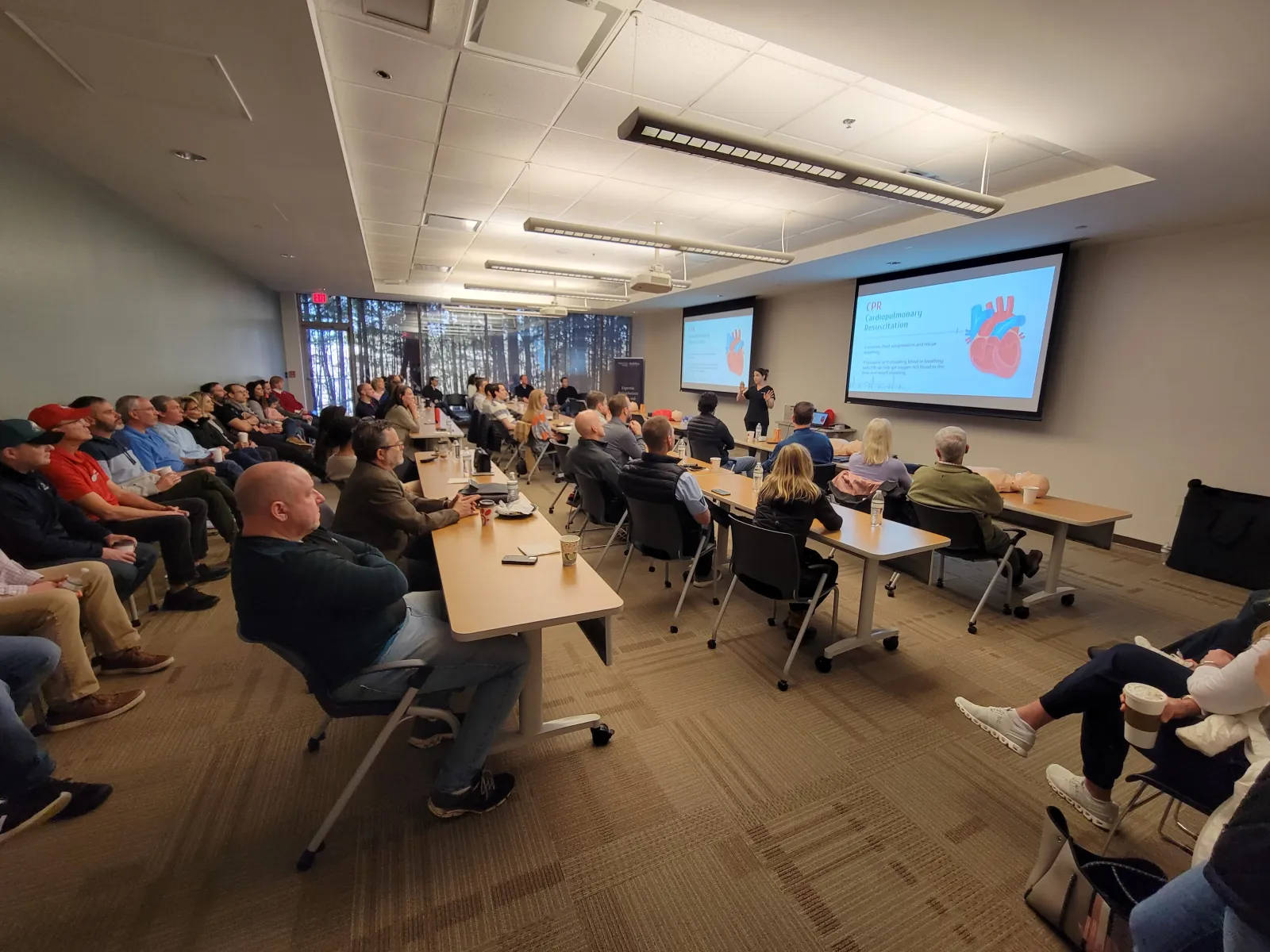 a group of people sitting in a room with a projector screen