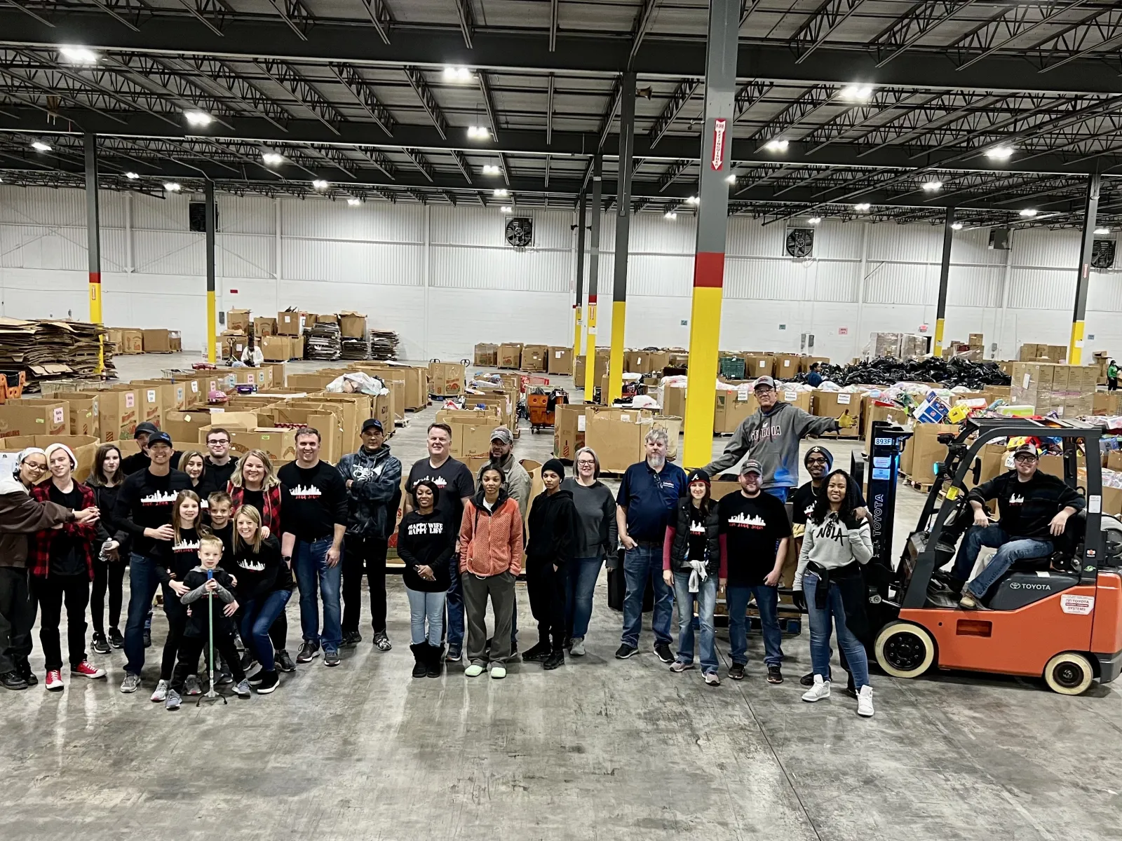 a group of people posing for a photo in a warehouse