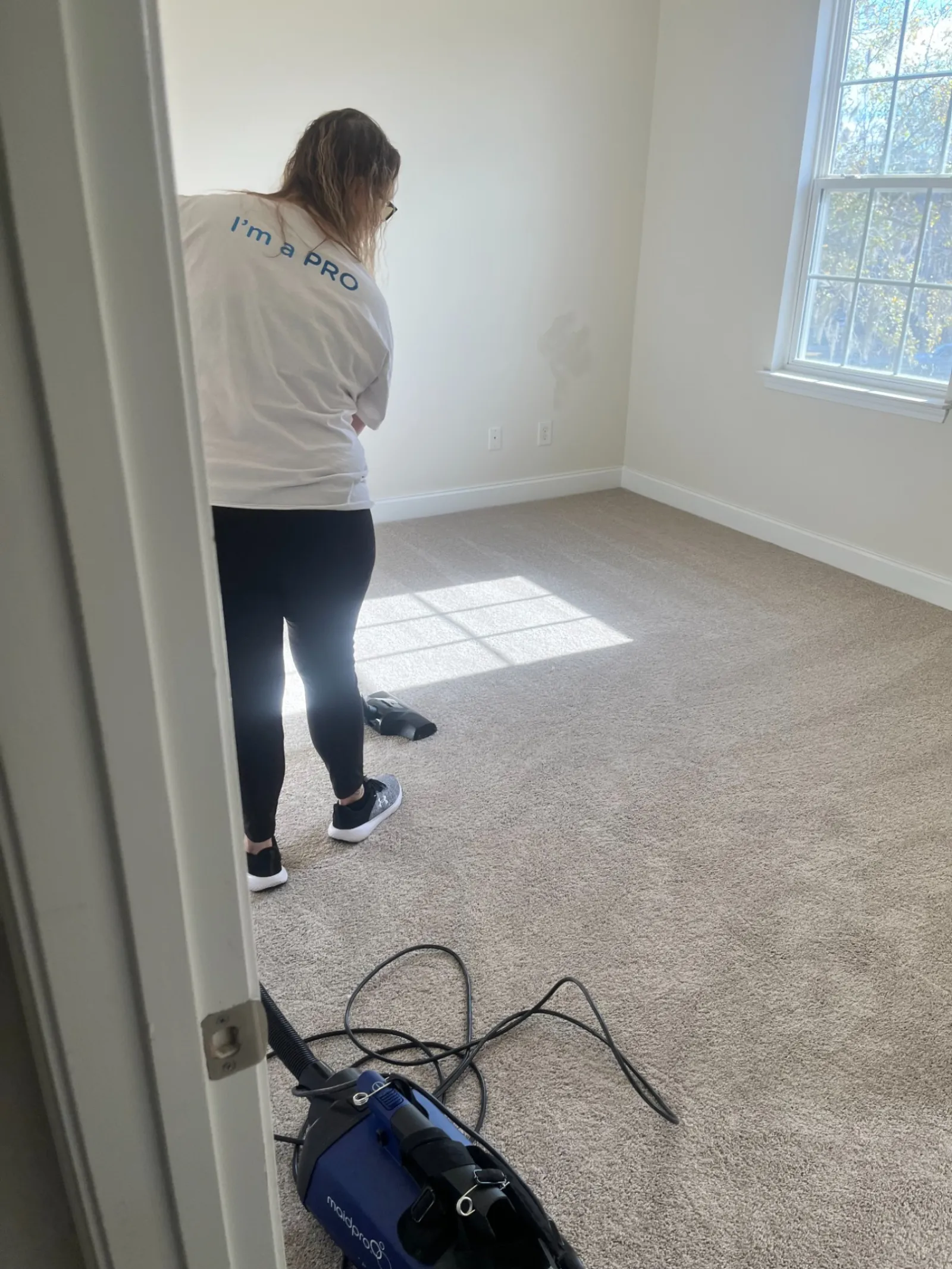 MaidPro PRO vaccuming a carpet in a bedroom