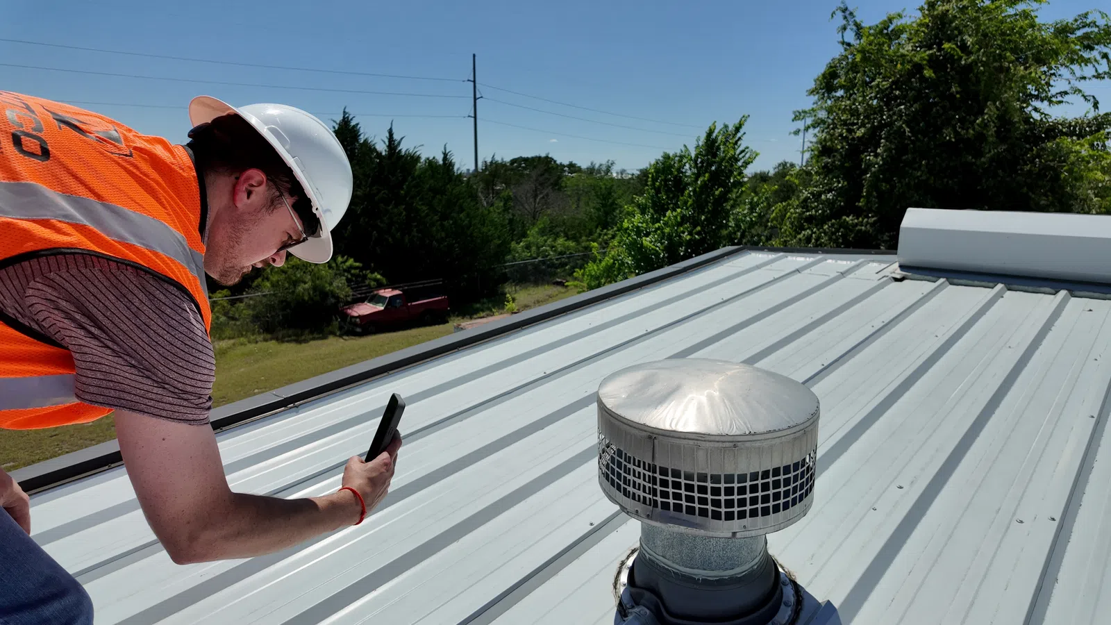 Professional roofer walking and inspecting standing seam metal roof panels on a commercial building