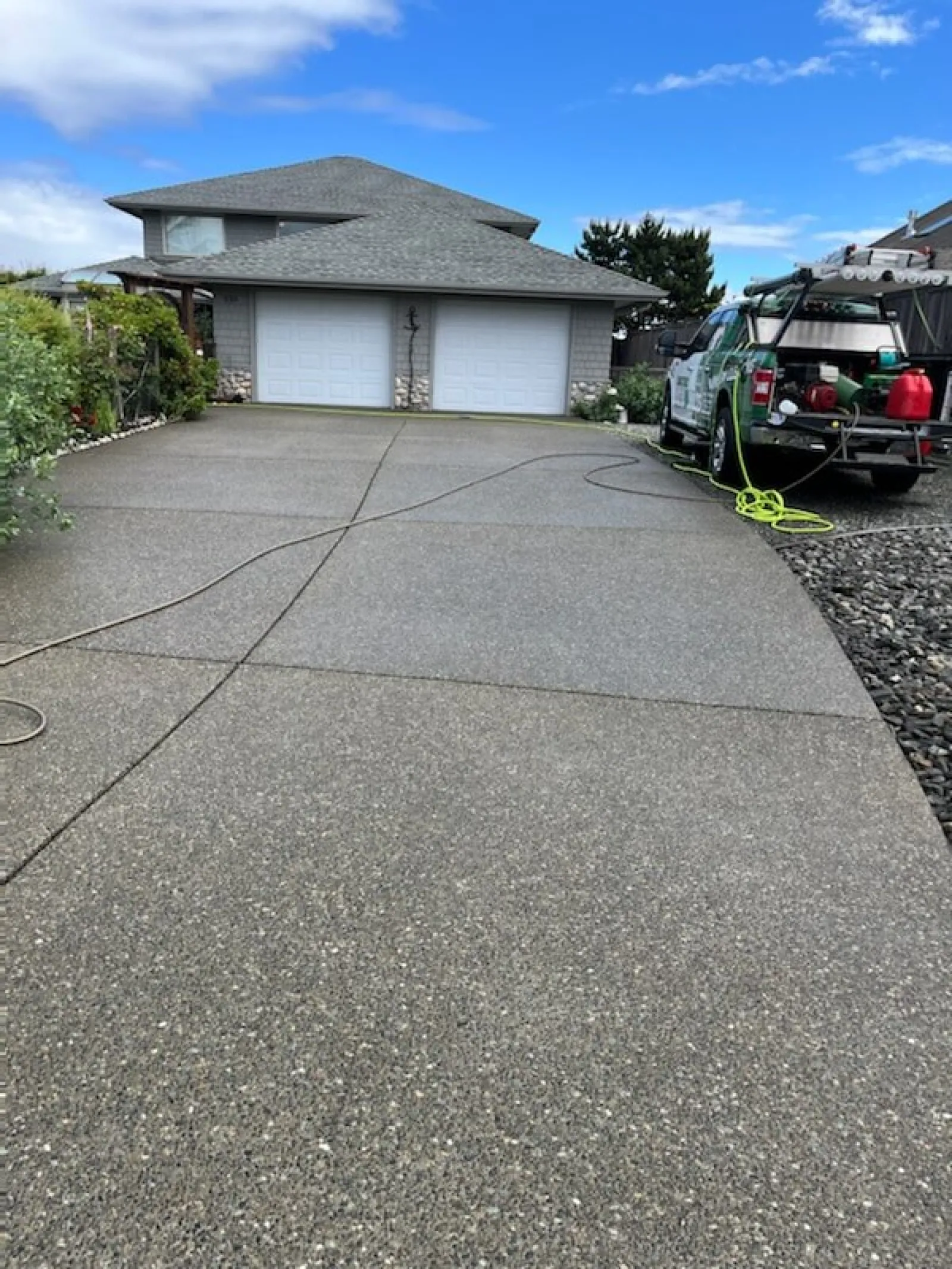 a driveway with a house and a tractor parked in the driveway