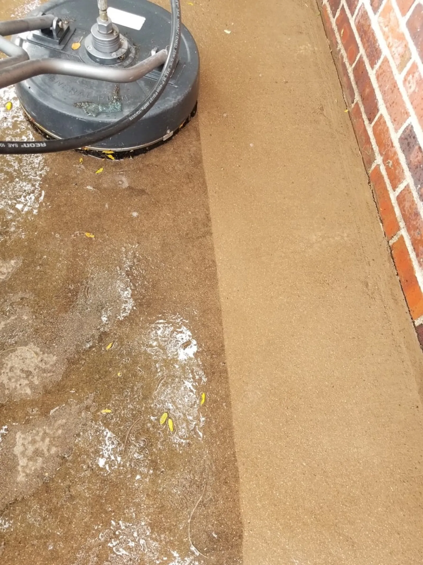 a dirty floor next to a brick wall