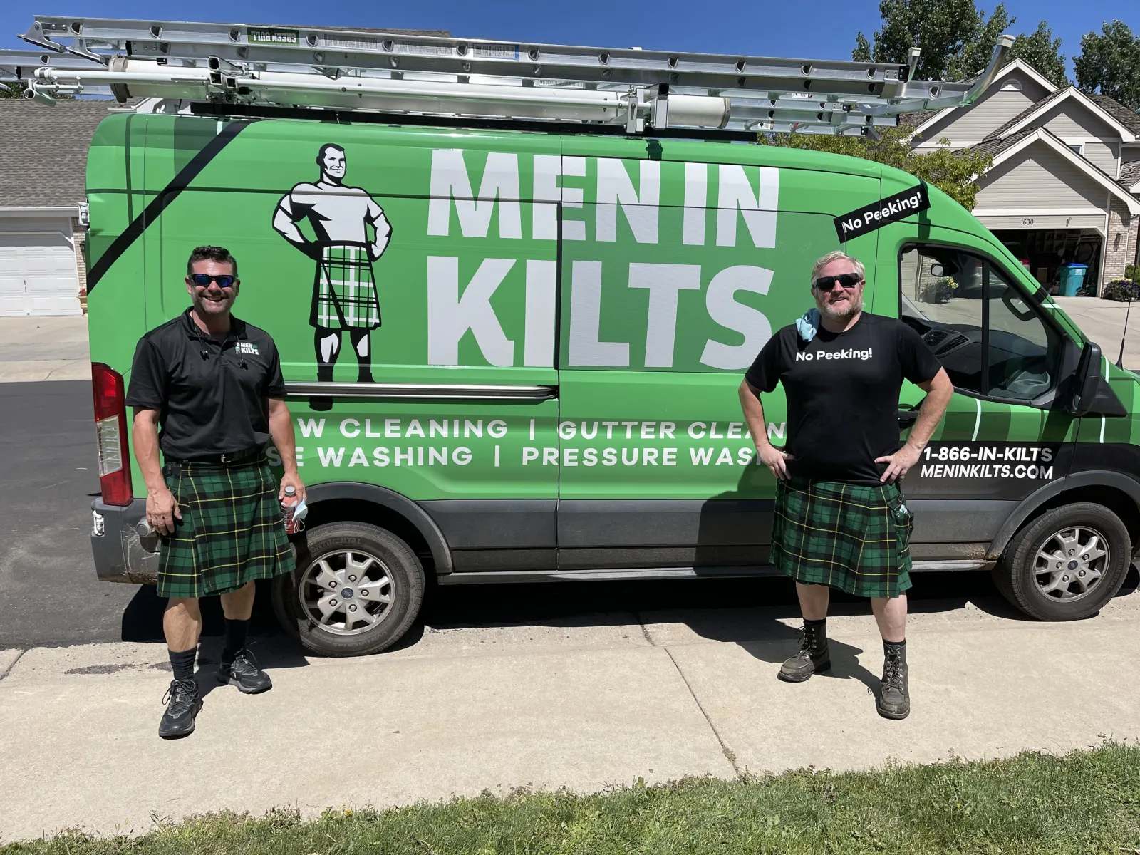 two men standing in front of a green van