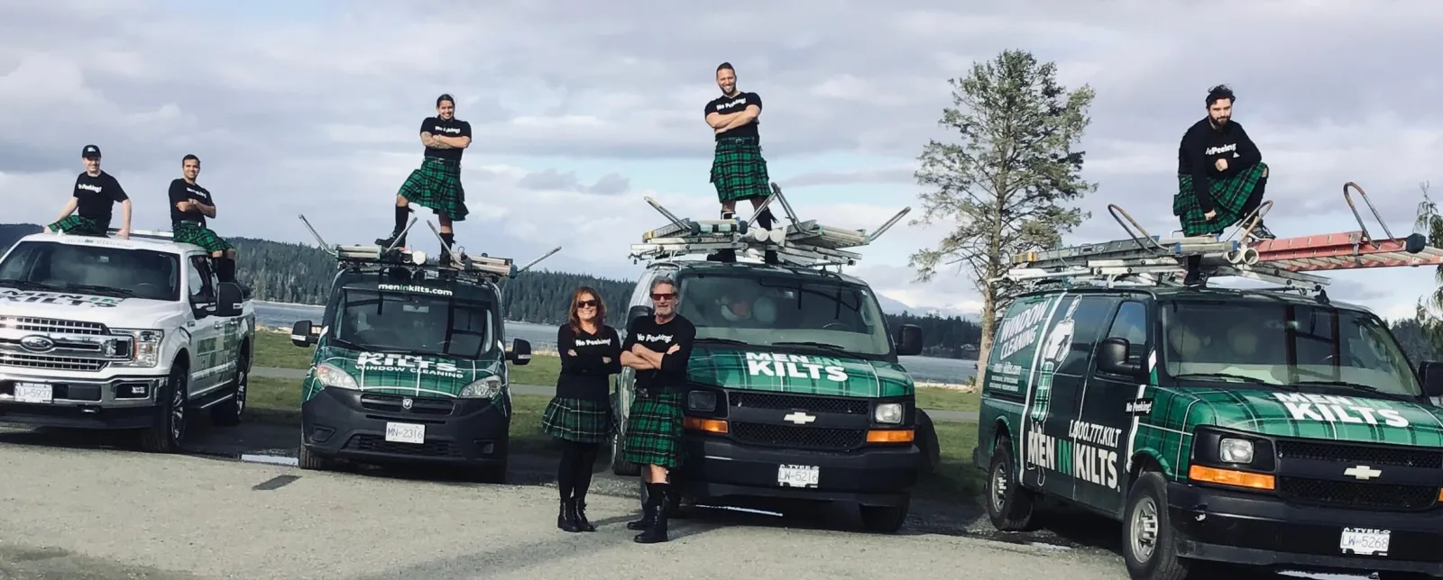 a group of people standing next to a group of cars