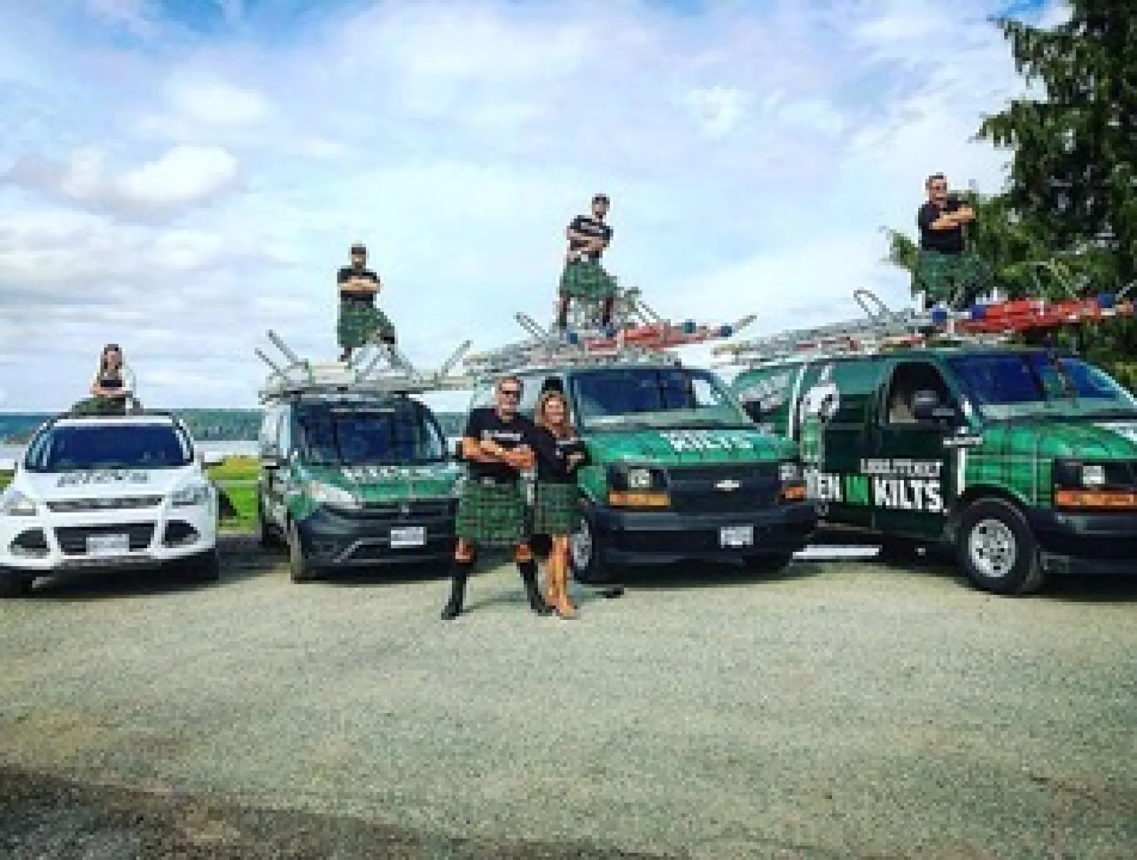 a group of people standing next to a row of cars