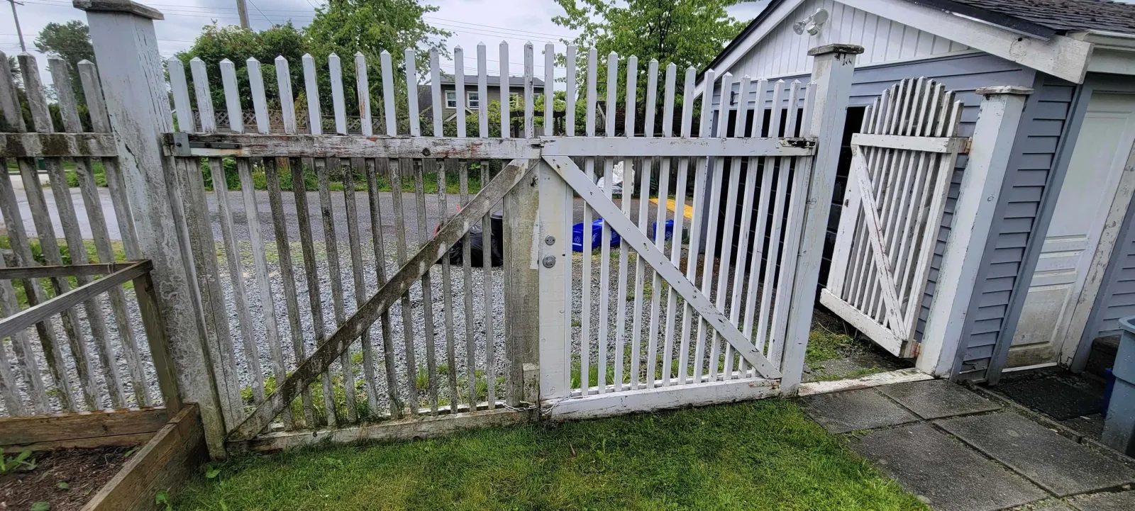 a white fence with a metal gate