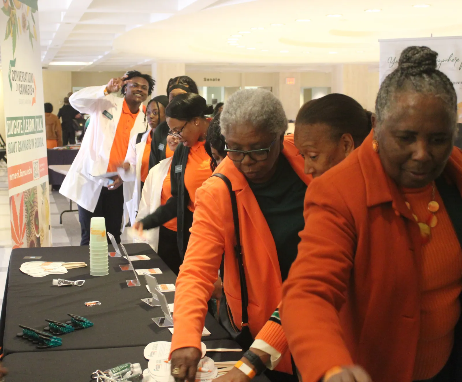 a group of people in orange vests looking at a paper