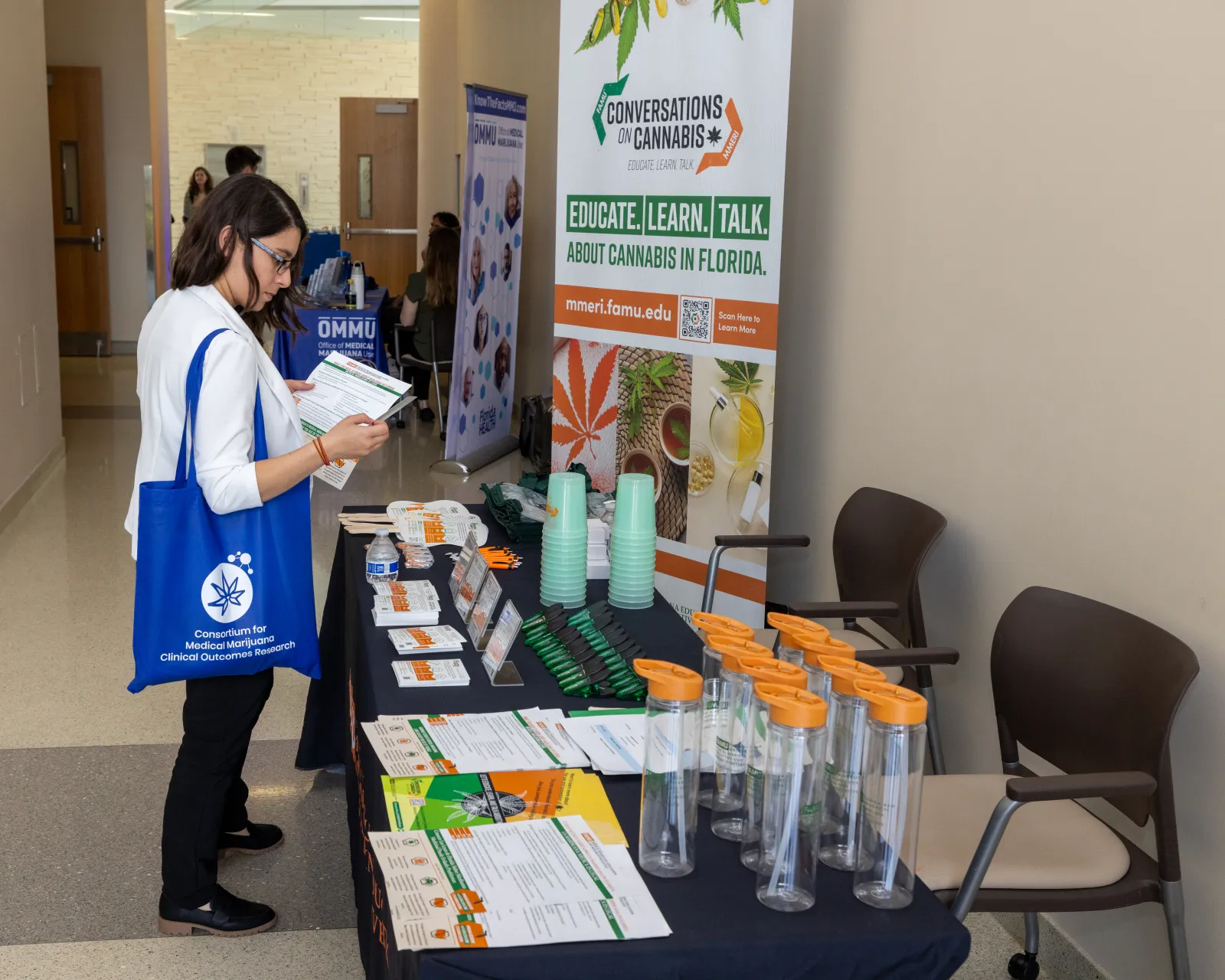 a person standing next to a table with glasses and papers on it