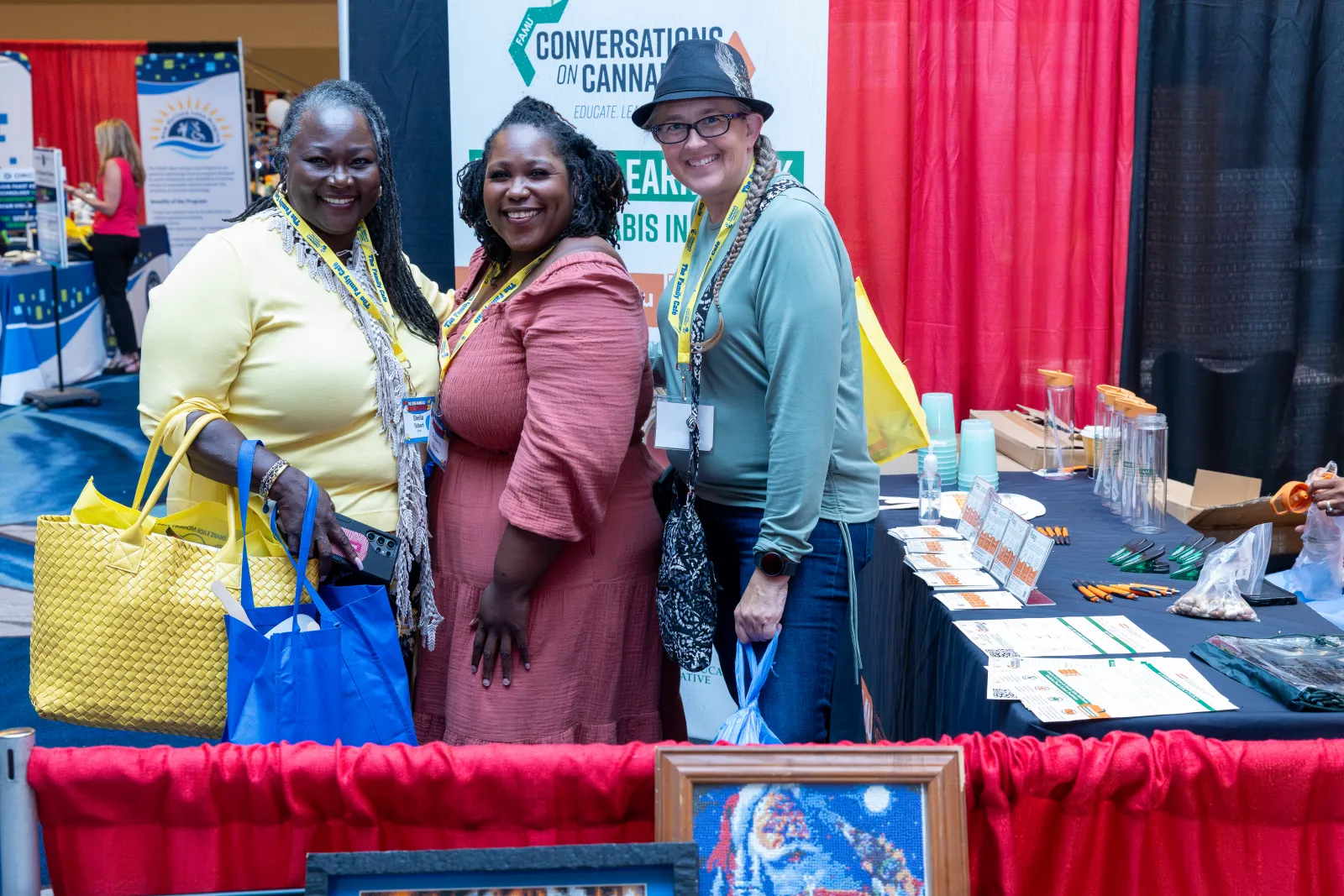 a group of women standing next to a table with bags